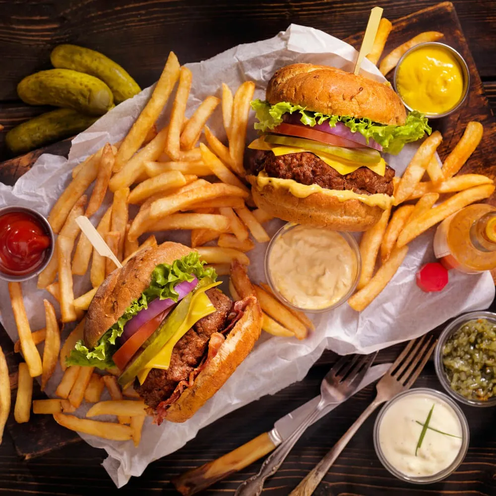 Overhead shot of two burgers and chips on a board