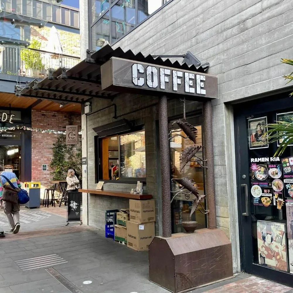 Espresso Studio, in Riverside Market laneway in Christchurch with person skateboarding past