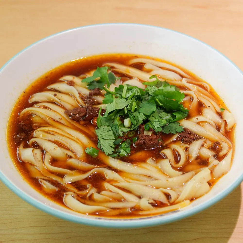 Noodles in broth in a white bowl