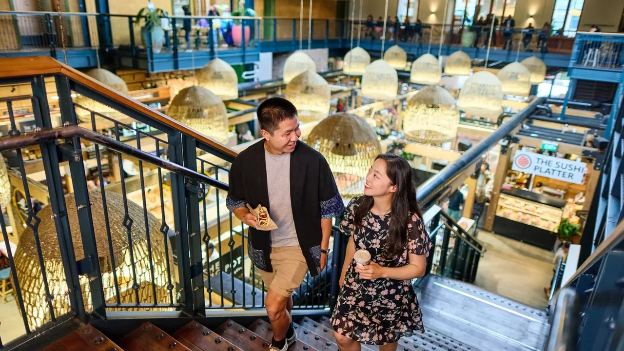 Two people walking up the stairs at Riverside Market