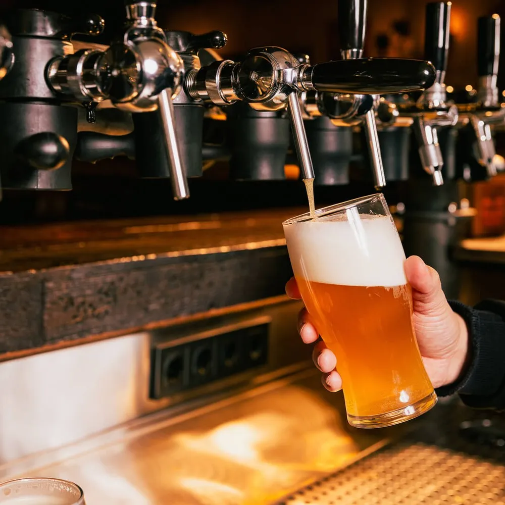 Person pouring beer from tap
