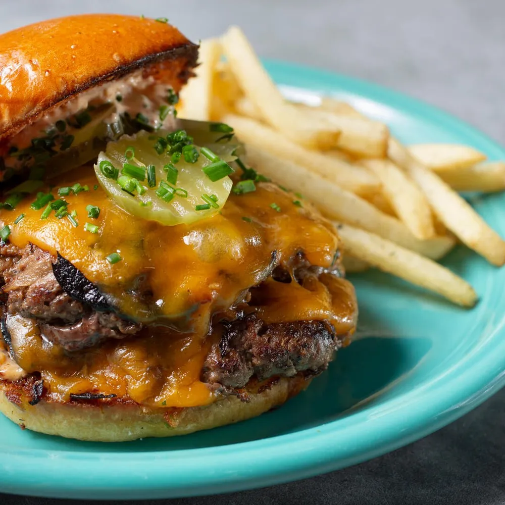 Smash burger and chips on blue plate