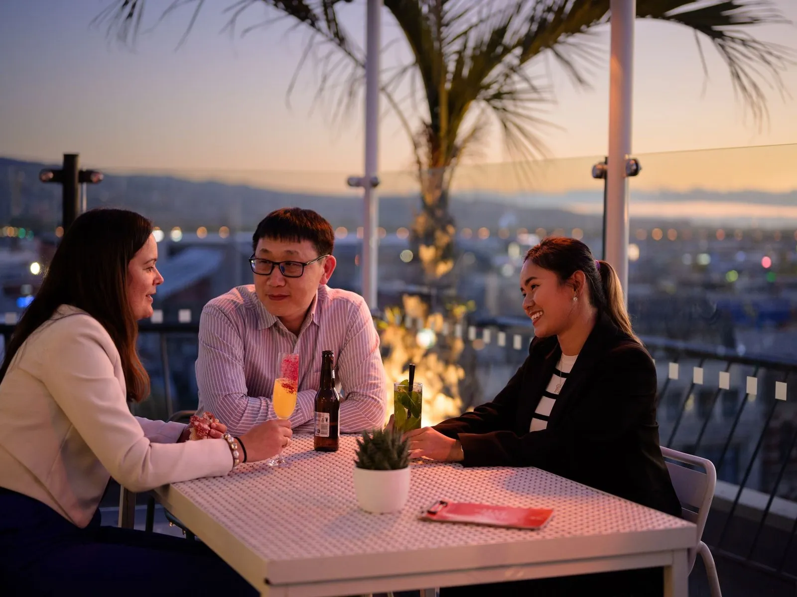 Friends enjoying a drink at a rooftop bar in summer