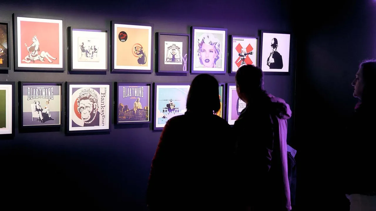 People looking at Banksy artworks