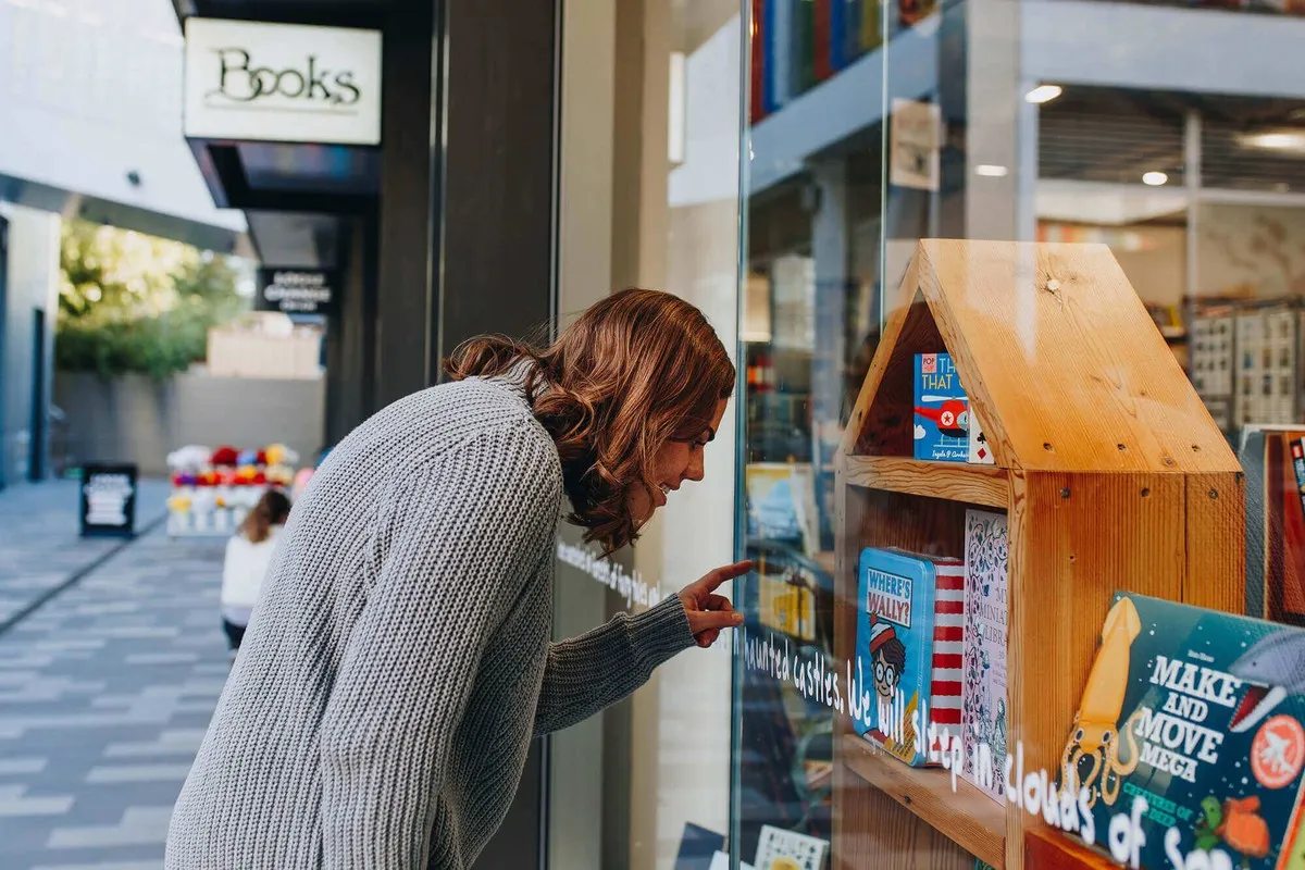 Lady looking in the windows at Scorpio Books