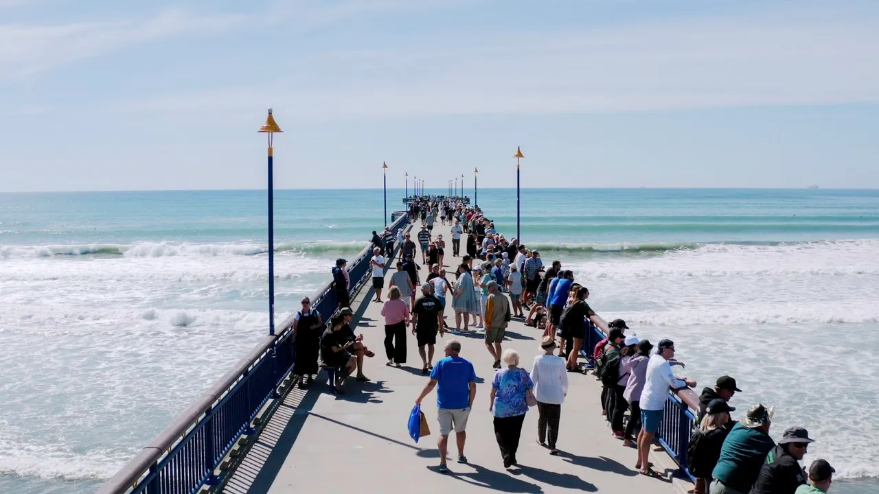 Lots of people enjoying a walk on New Brighton Pier.