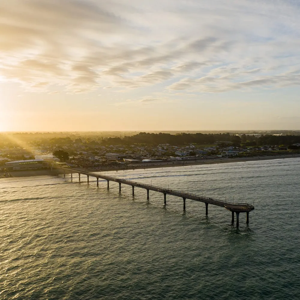 Coastal shot of New Brighton Pier with the sunset behind.