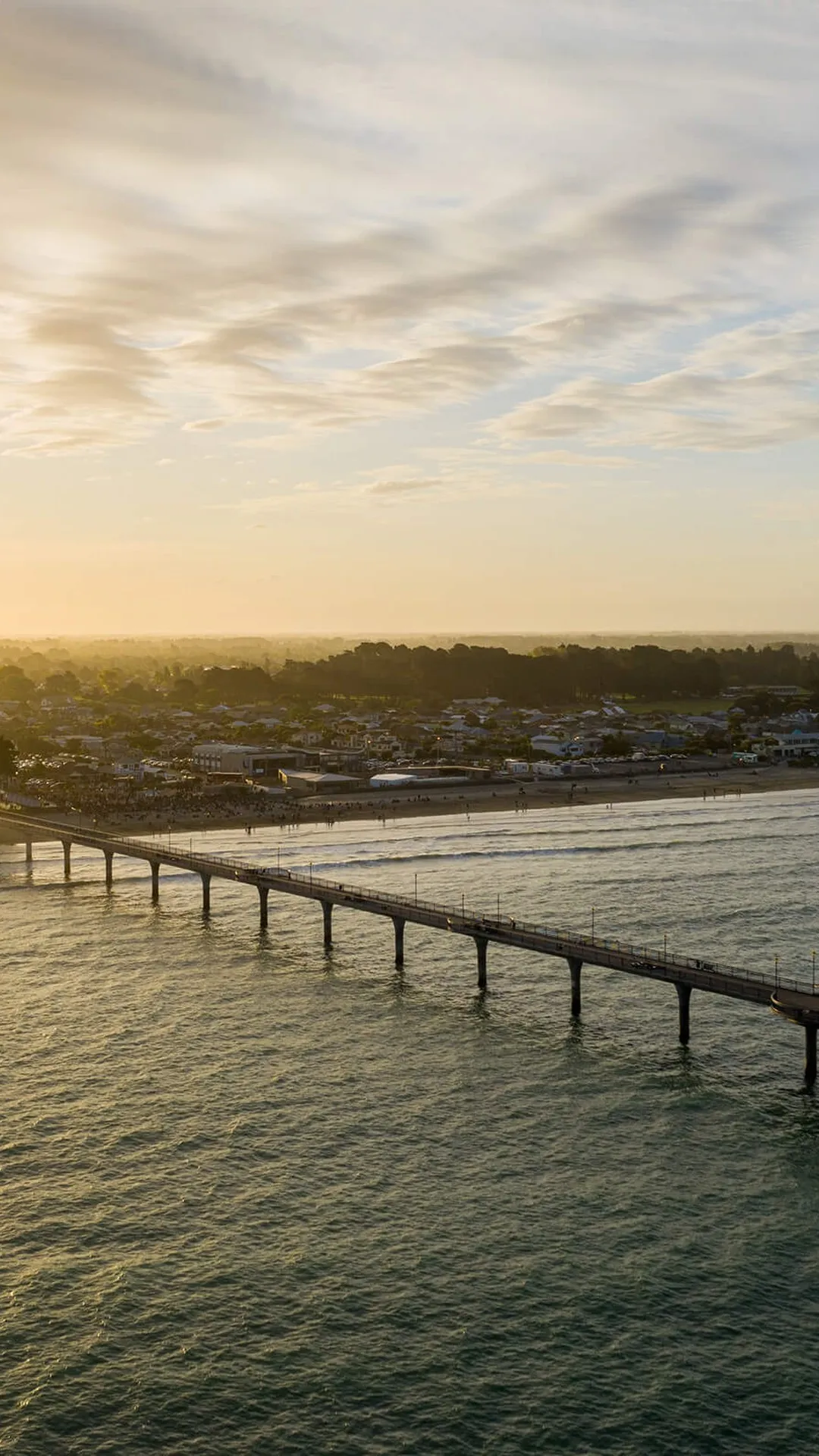 Coastal shot of New Brighton Pier with the sunset behind.