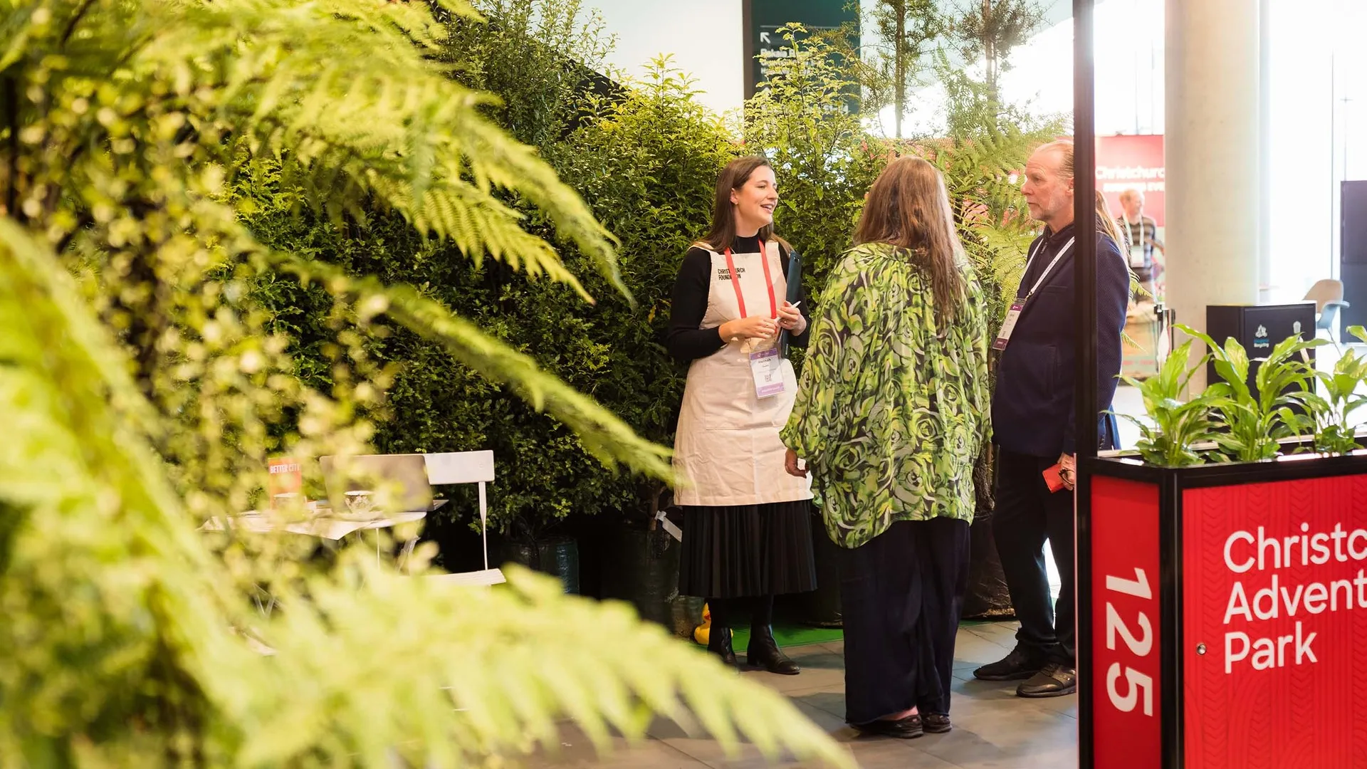 Lady speaking to a couple at a conference about sustainable vendors