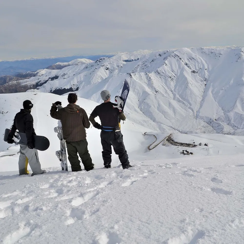 three snowboarders standing on the top of mt lyford