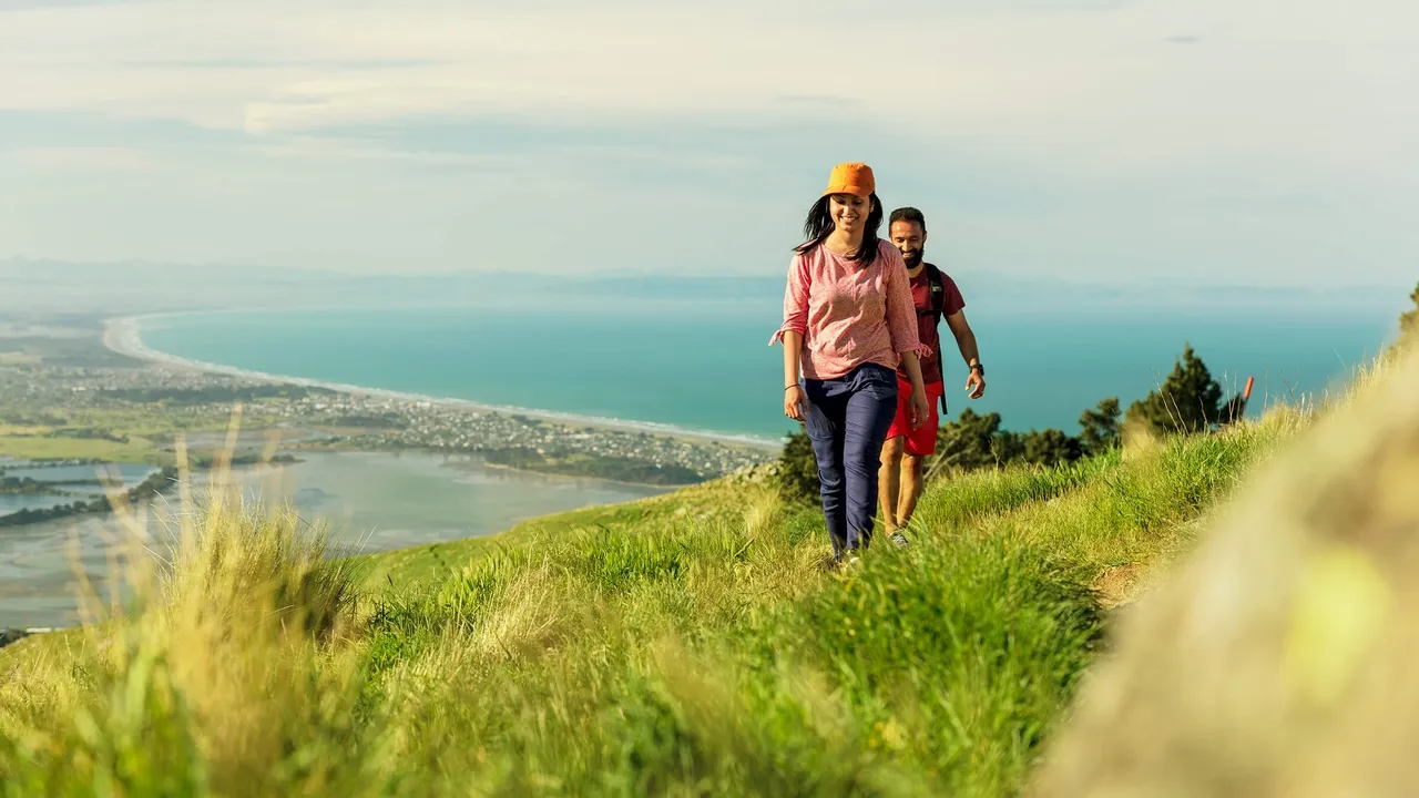 Friends walking in the Port Hills Christchurch with the Christchurch coastline in the background.