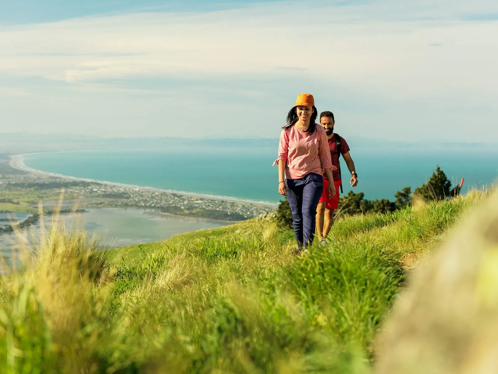Friends walking in the Port Hills Christchurch with the Christchurch coastline in the background.