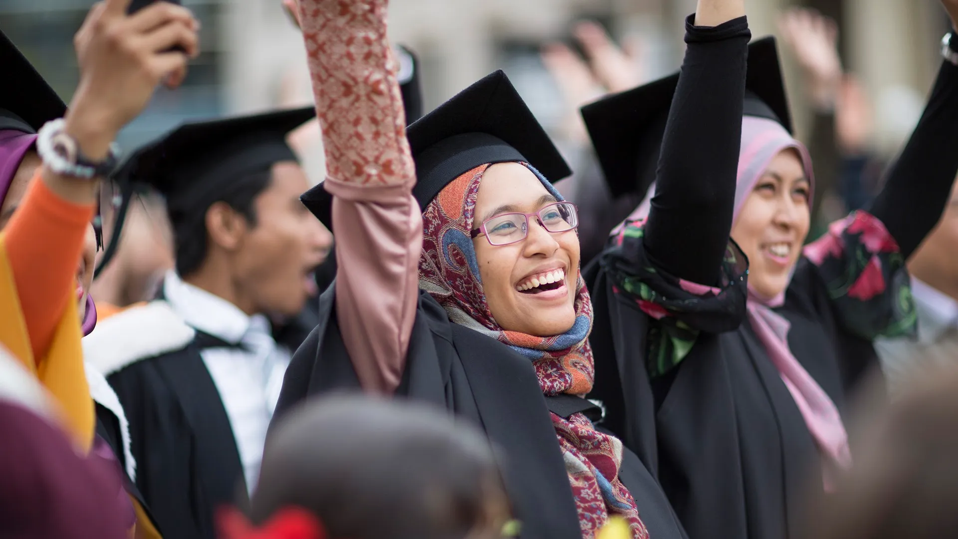 Group taking their caps off at graduation