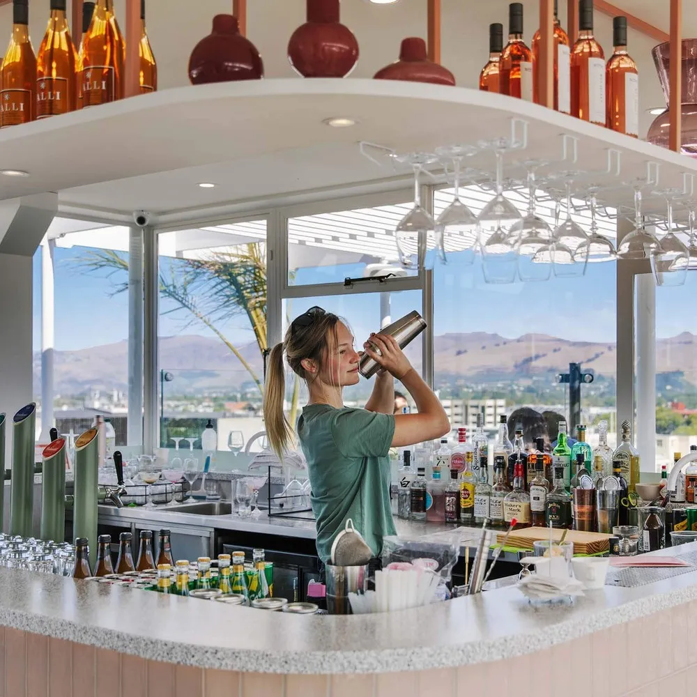Lady shaking cocktails at The Pink Lady