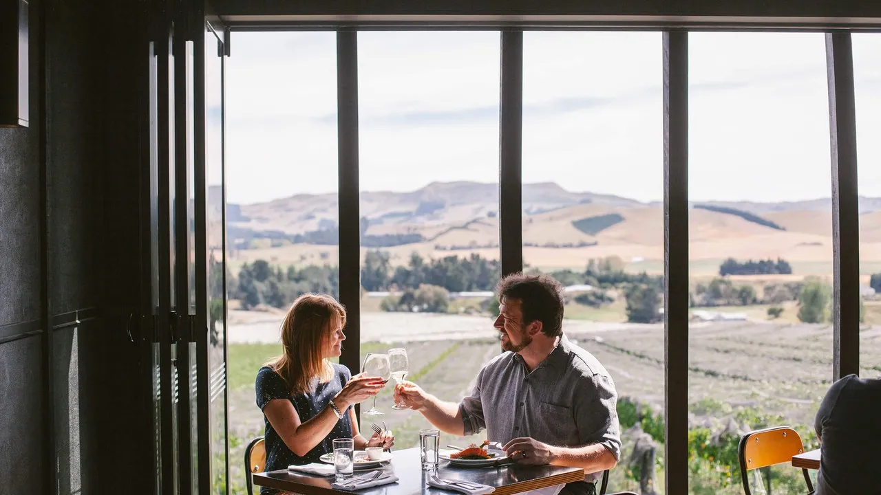 Black Estate front shot of dining couple clinking glasses