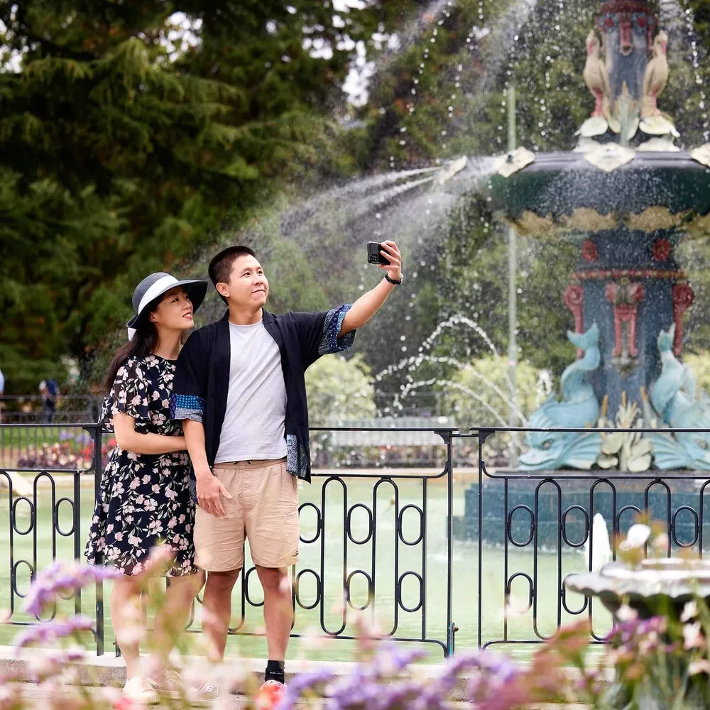 Couple taking a selfie in front of Peacock Fountain in the Botanic Gardens.