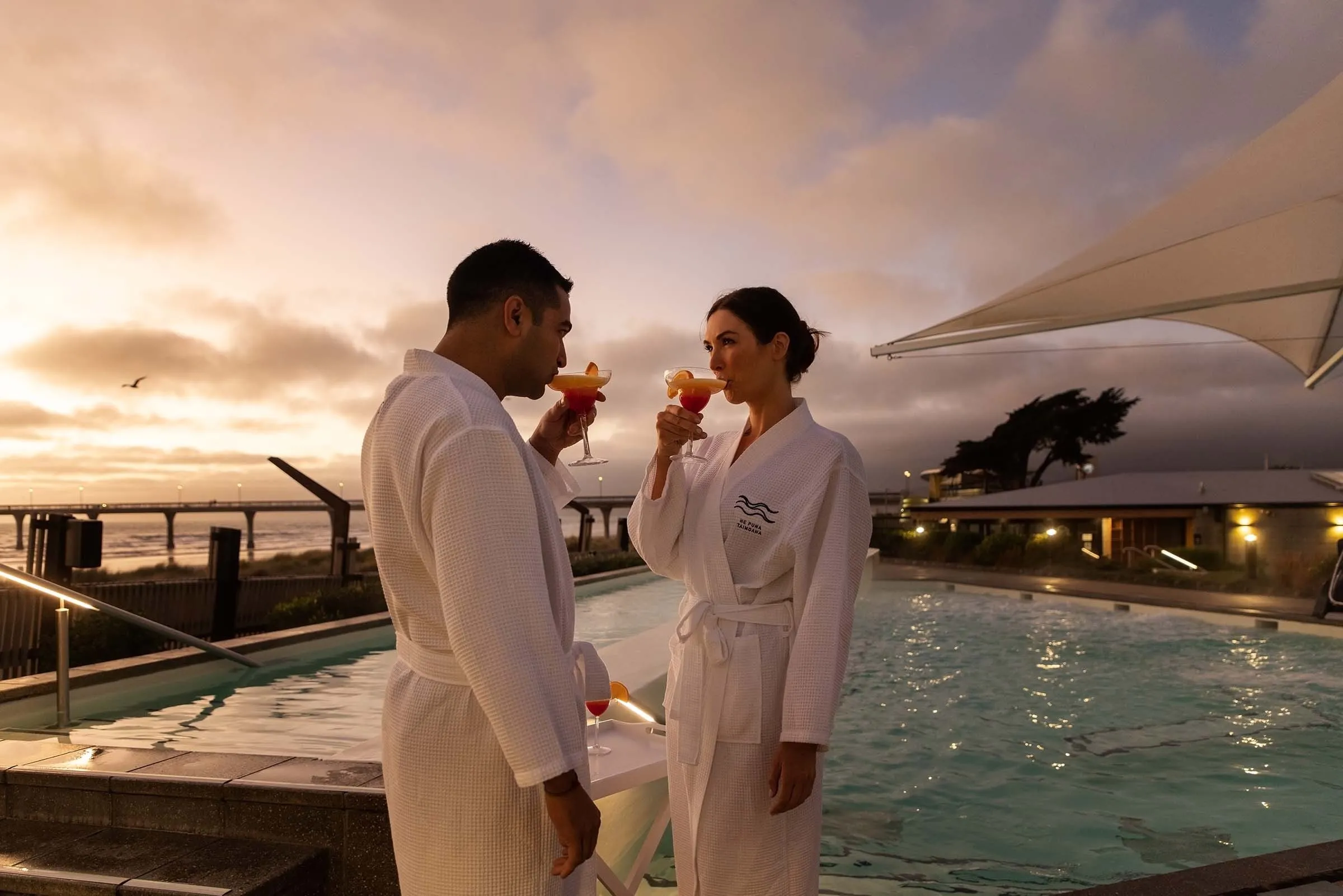 Couple enjoying a sunrise soak at He Puna Taimoana