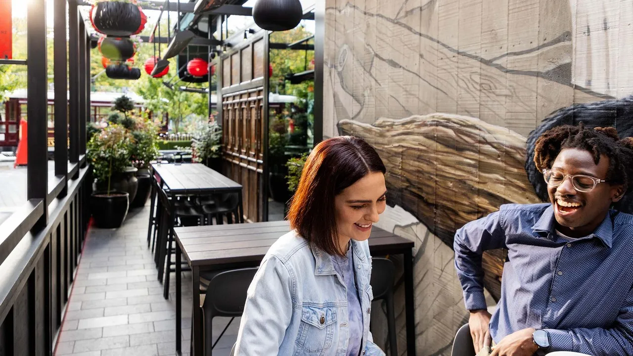 A couple enjoying food and drinks on The Terrace