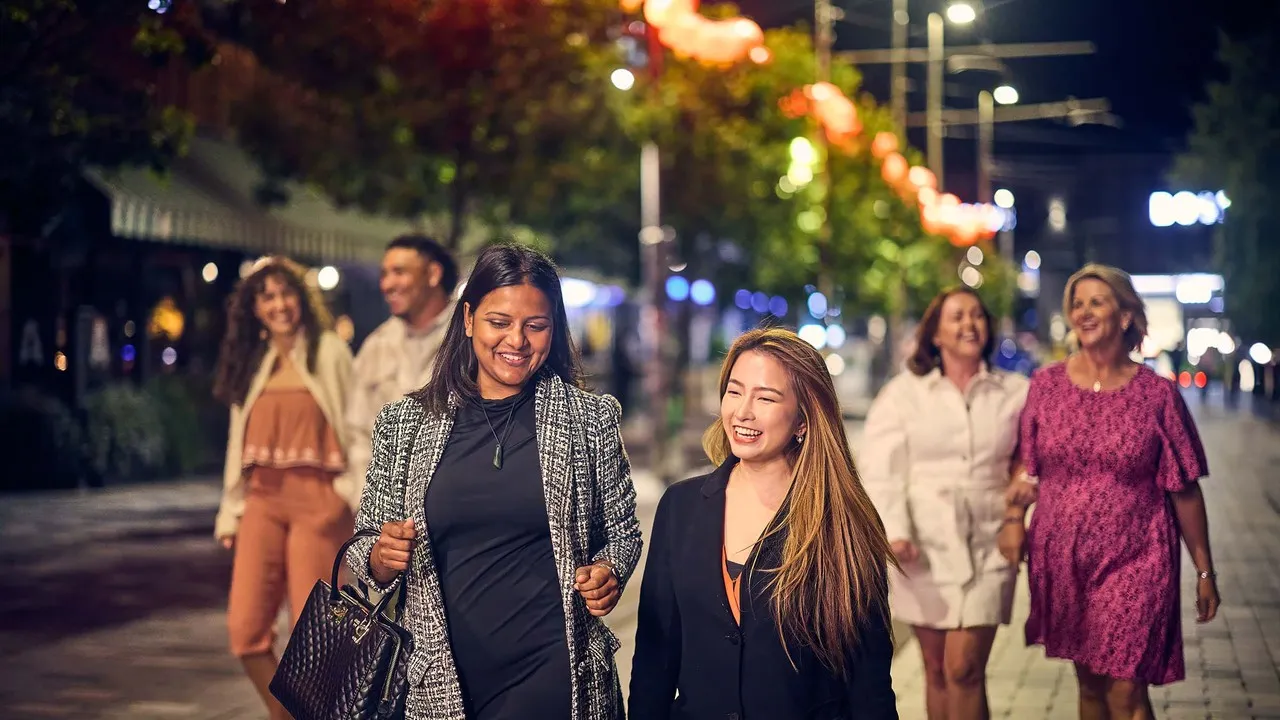 Friends strolling Oxford Terrace at night.
