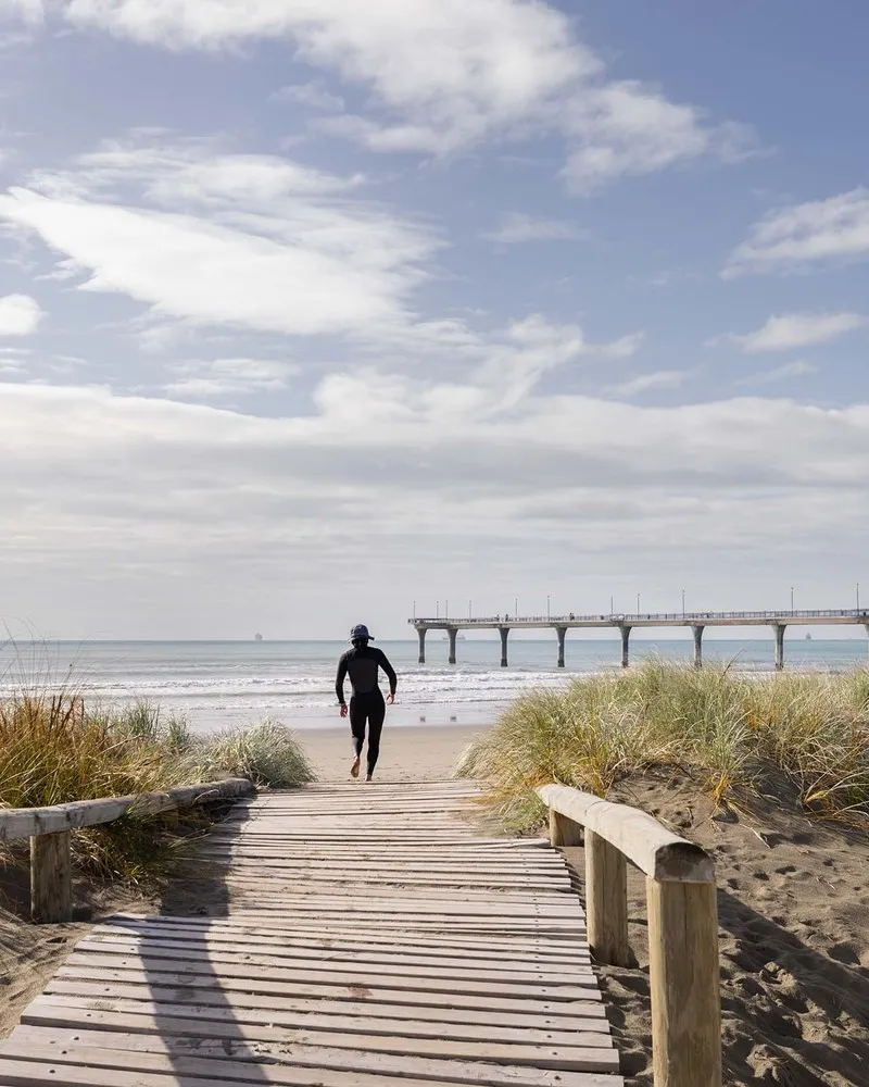 Man on boardwalk to New Brighton Beach.