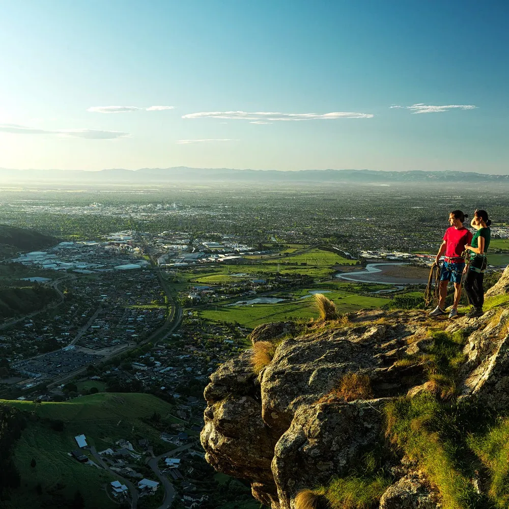 Two climbers on the Port Hills looking out over the city.