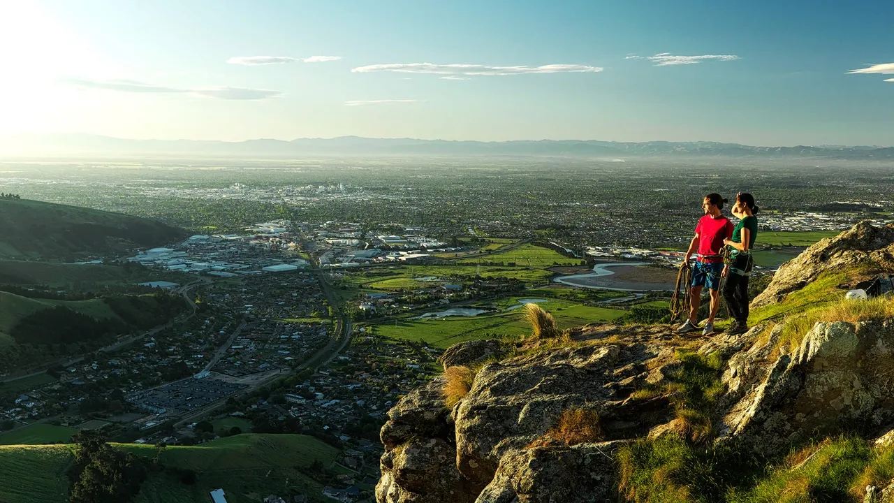 Two climbers on the Port Hills looking out over the city.