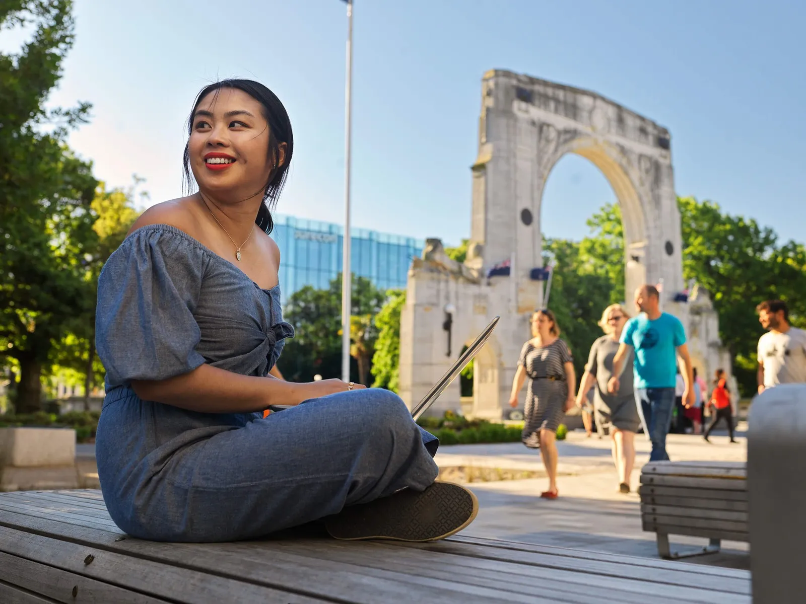 Girl working on her laptop in front of the Bridge of Remembrance.
