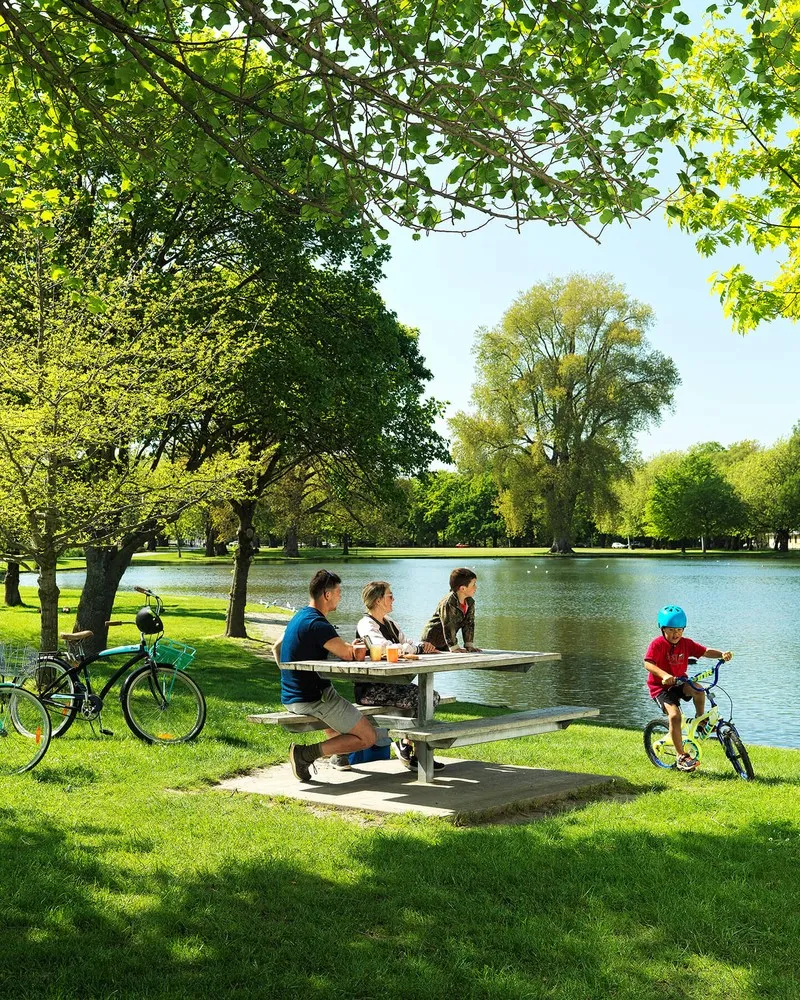 Family hanging out at the lake within Hagley Park Christchurch.