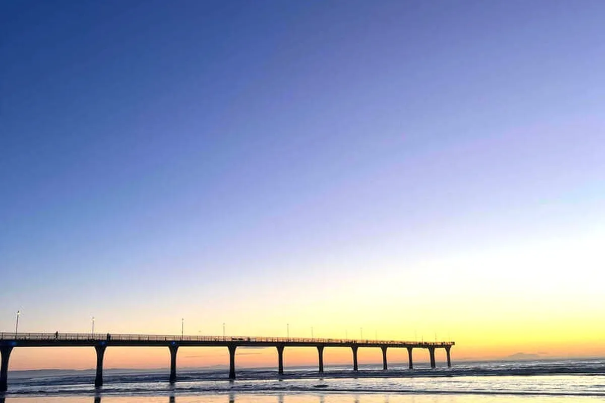 New Brighton Pier at sunrise with seagulls on the shore
