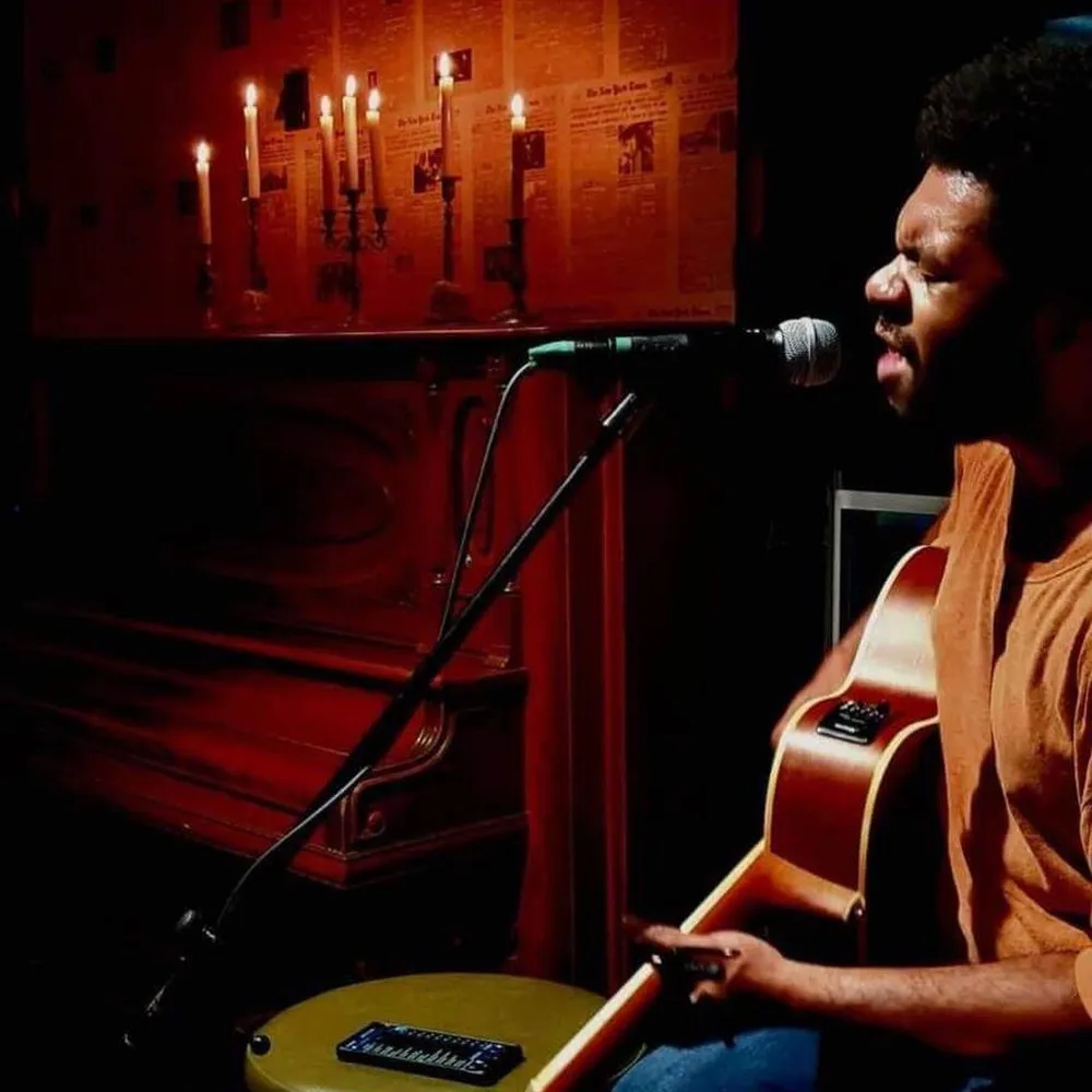 Man singing and playing guitar at Boos