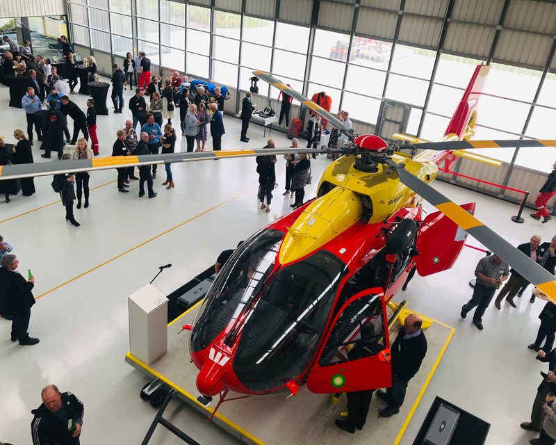 Collective Concepts Helicopter Display. attendees mingle around the aircraft hanger. A westpac helicopter is open for viewing
