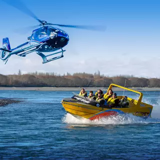 Garden City Heli hovers over a Jetboat on the river