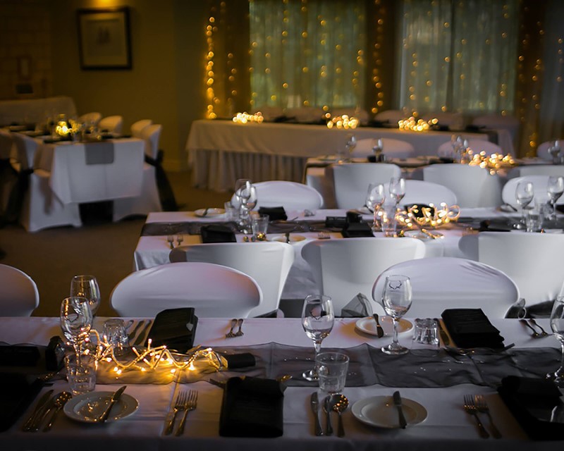 Hanmer Springs Retreat function set up for a Wedding, long white tables and fairy light backdrop 
