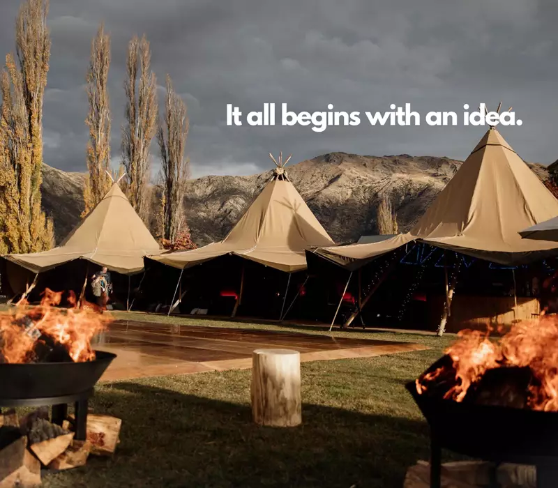 Tents set up in a open space framed by dramatic mountains. Text reads: It All Begins With An Idea