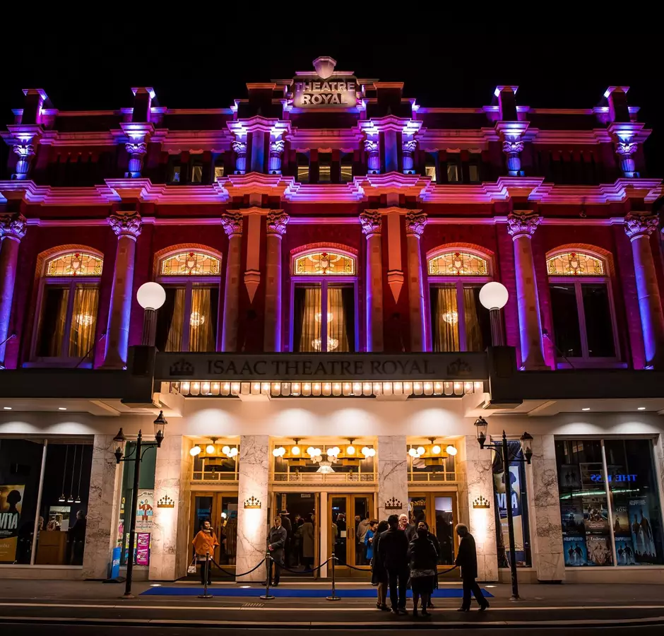 Isaac Theatre Royal night lights illuminating the building in purple and red 