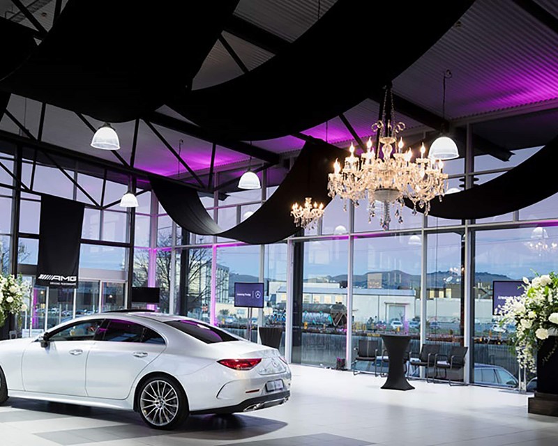 AMG South Island Showroom Launch, large open space with a vehicle in the middle. Around the room are plinths with large white floral bouquets 