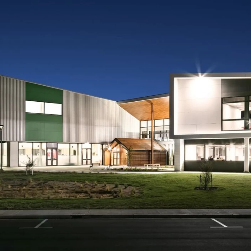 Rolleston College building exterior with lights on.